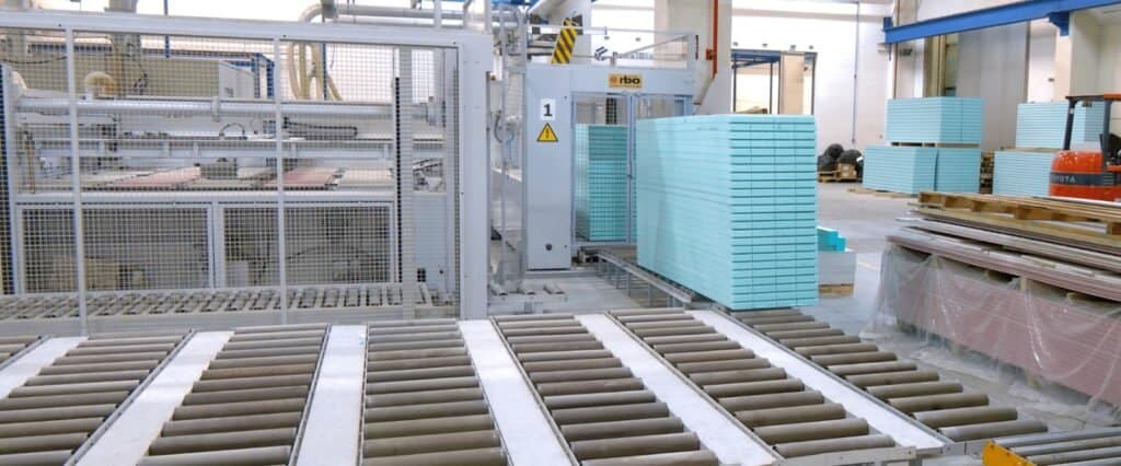 Fábrica con máquina y paneles apilados