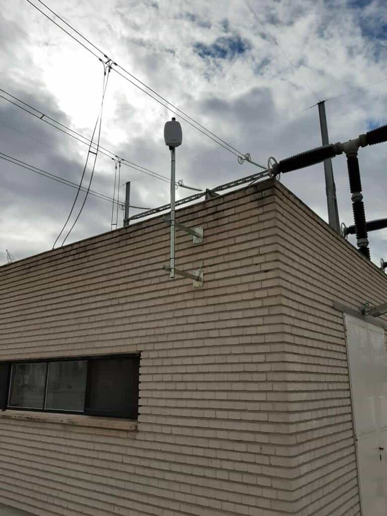 Edificio de ladrillo con cables eléctricos y cielo nublado.
