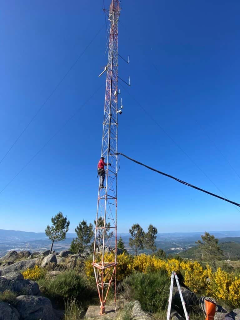 Técnico subiendo torre de telecomunicaciones en montaña